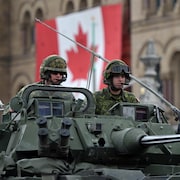 Des soldats canadiens à bord d'un véhicule blindé léger lors d'un défilé, à Ottawa, le 9 mai 2014.