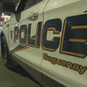 Un véhicule du Service de police de Saguenay circule dans une rue. 