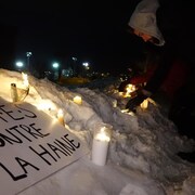 Un homme allume une chandelle lors d'une veillée à Sherbrooke en solidarité avec les victimes survenues dans une mosquée de Québec 