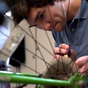 Caymen Hall, jeune bénévole, répare la roue d'un vélo