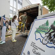 des jeunes qui mettent des vélos dans un camion.