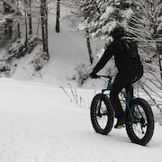 Un cycliste roule sur la neige 