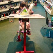 Solène Bergman, 3 ans, profitant d'un vélo-pupitre installé il y a une semaine dans la Bibliothèque Robert-Bourassa dans l'arrondissement d'Outremont.