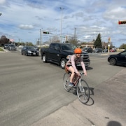 Un cycliste traverse une rue à Moncton.