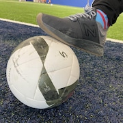 Un pied sur un ballon de soccer.