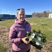Véronique Leblanc tient une boîte de plants à cultiver.