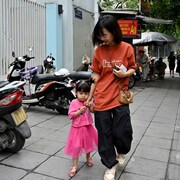 Une femme marche aux côtés d'une enfant.