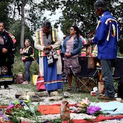 Des personnes se recueillent dans un parc.      