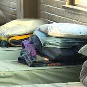 Des couvertures, des oreillers et des serviettes sur des lits dans un refuge.