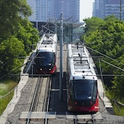 Deux trains sur rail d'Ottawa circulent le long des voies. 