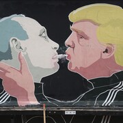 Une peinture sur un mur de Vilnius, en Lituanie, dépeint le président désigné Donald Trump soufflant de la fumée de marijuana dans la bouche du président russe Vladimir Poutine.
