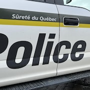 Une voiture de la Sûreté du Québec près d'un feu d'arrêt.