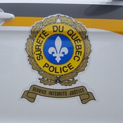 Le logo de la Sûreté du Québec apparaît sur la portière d'une voiture de patrouille.