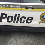 Porte d'une voiture de police de la Sûreté du Québec avec le logo.