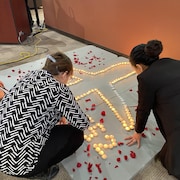 Des bougies placées pour former un avion, en souvenir du vol PS752, à l'intérieur de la chapelle de l'Université de la Saskatchewan. 