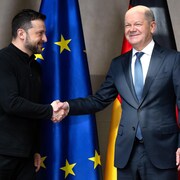 Le chancelier allemand Olaf Scholz (à droite) serre la main du président ukrainien Volodymyr Zelensky lors d'une réunion bilatérale en marge de la 61e Conférence de Munich sur la sécurité, le 15 février 2025.