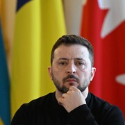 Le président ukrainien, Volodymyr Zelensky, regarde devant lui, le poing sous le menton.