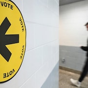 Un homme entre dans un bureau de vote.
