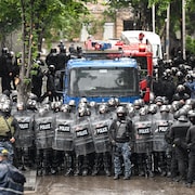 Des policiers antiémeutes en rangs serrés.