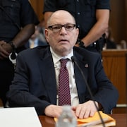 Harvey Weinstein est assis devant le tribunal.