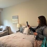 Une femme prend en photo une chambre.