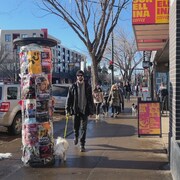 Une personne marchant sur un trottoir avec son chien.