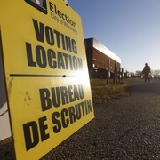 Un panneau indique l'emplacement d'un bureau de vote.
