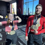Les deux haltérophiles posent pour la caméra avec leurs médailles au cou.