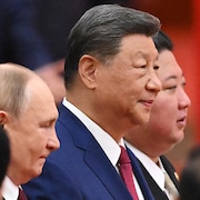 Xi Jinping est debout entre Vladimir Poutine et Kim Jong-un.