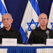 MM. Nétanyahou et Gallant sont assis devant des drapeaux d'Israël.