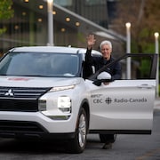 Yves Desautels fait un signe de main en entrant dans une voiture de Radio-Canada. 