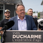 Yves Ducharme derrière un podium, pendant un point de presse.