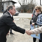 Yves-Francois Blanchet serre la main d'une femme qui tient une pancarte du Bloc québecois.