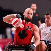 Un hommes en fauteuil roulant qui tente de se démarquer lors d'une match.