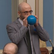 M. Zanetti soufflant dans un ballon.