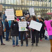 Des manifestants avec des pancartes dont les slogans appellent au rejet de la réforme.