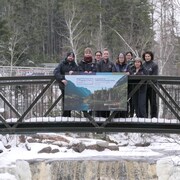 Des personnes se tiennent sur un pont piétonnier en hiver.
