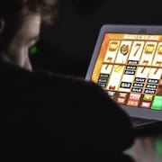 Une personne joue à des jeux de hasard en ligne sur sa tablette.