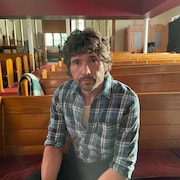 Un homme assis dans une église. 