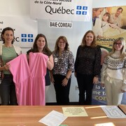 Les cinq femmes, côte à côte, montrent un vêtement rose.