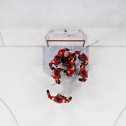 Des joueurs de l'équipe masculine de hockey du Canada se font une accolade.