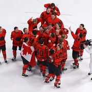 Les Canadiennes célèbrent leur victoire au milieu de la patinoire. 