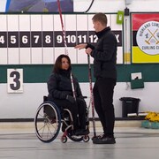 La joueuse de curling en fauteuil roulant Collinda Joseph et son entraîneur Mick Lizmore discutent lors d'un entraînement.