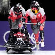 Melissa Lotholz et Kelsey Mitchell poussent leur bobsleigh sur la piste en début de descente.