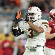 Un joueur de football fait un U avec ses mains apr&egrave;s avoir plaqu&eacute; un adversaire.
