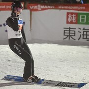 La sauteuse à ski Alexandria Loutitt serre les dents et son poing droit après un atterrissage.