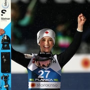 La jeune femme avec une tuque du Canada célèbre sa victoire en levant les bras dans les airs.