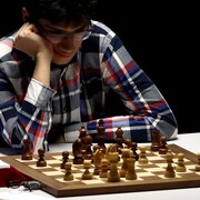 Un homme regarde intensément un plateau d'échecs.