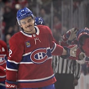 Un hockeyeur célèbre un but devant le banc de son équipe.
