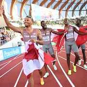 Andre De Grasse, Brendon Rodney, Aaron Brown et Jerome Blake célèbrent leur victoire avec des drapeaux canadiens.